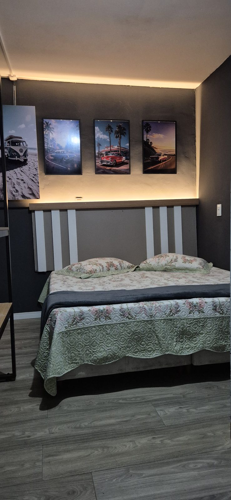 Quarto Roddertown 05 — Vista do quarto com cama, quadros e piso claro