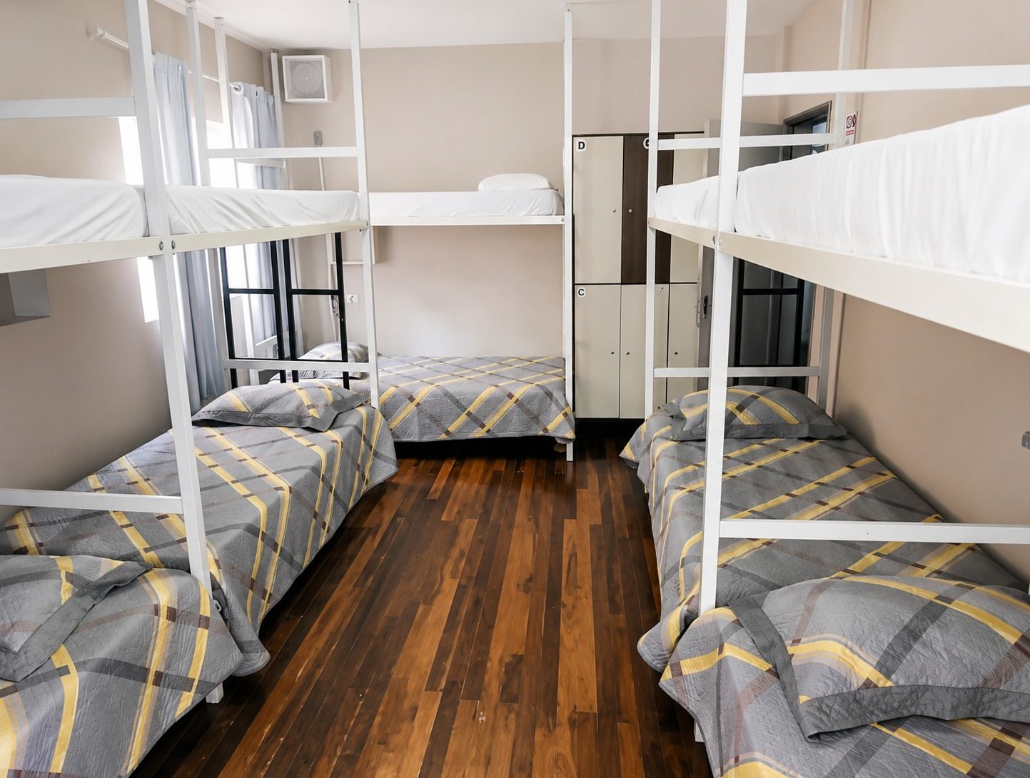 Quarto compartilhado com beliches e piso de madeira