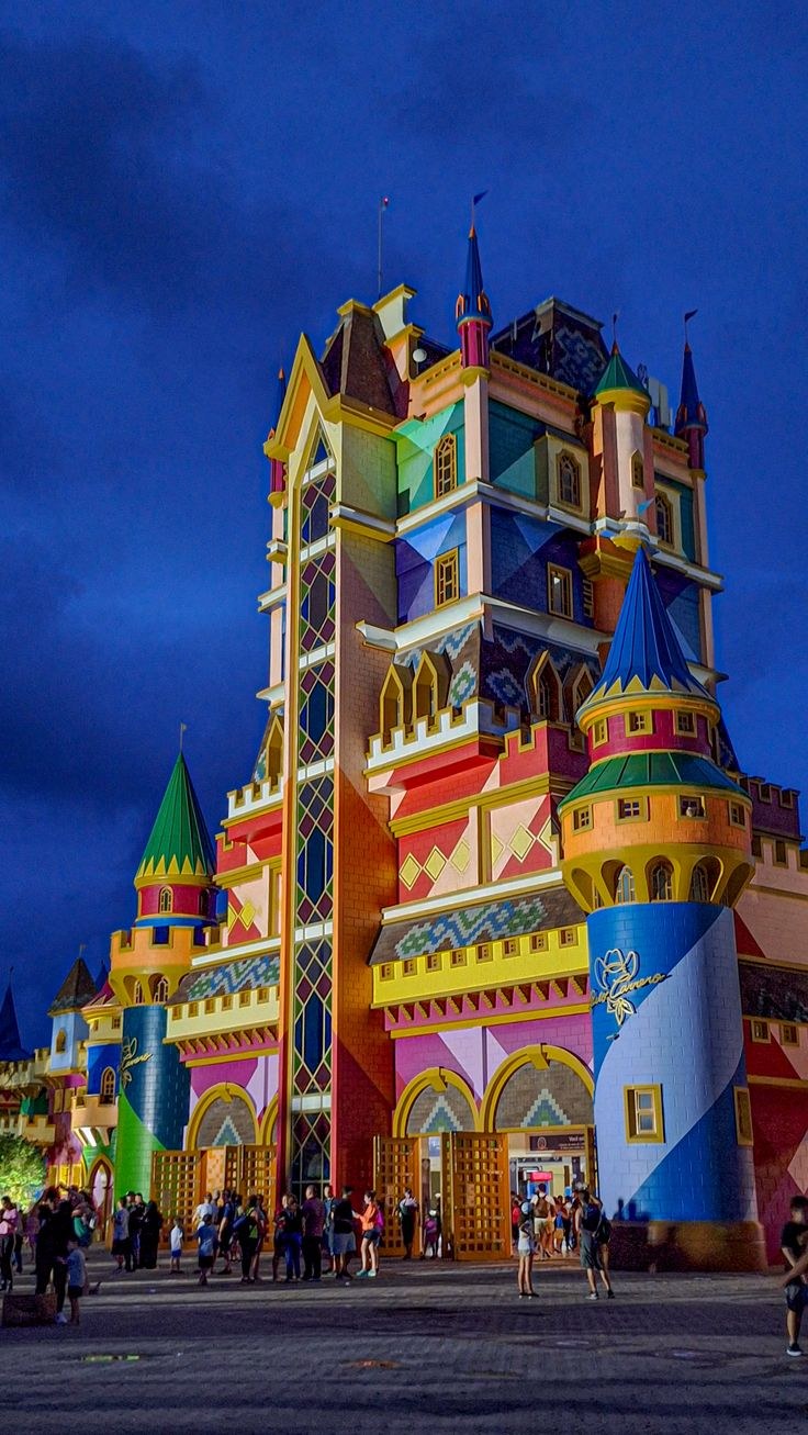Parque temático com montanha-russa e castelo ao fundo