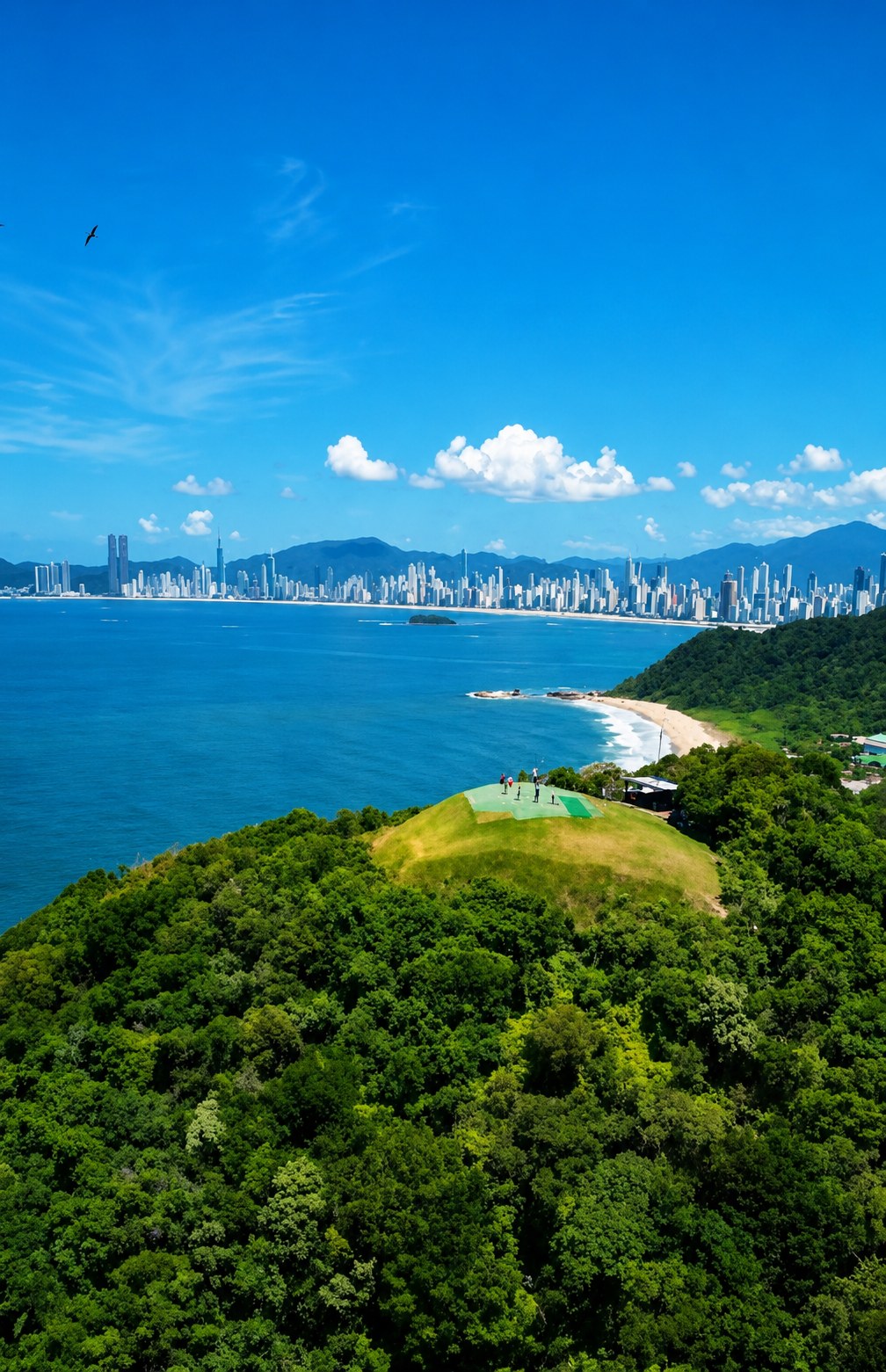 Vista panorâmica de morro verde à beira-mar com praticante de voo livre