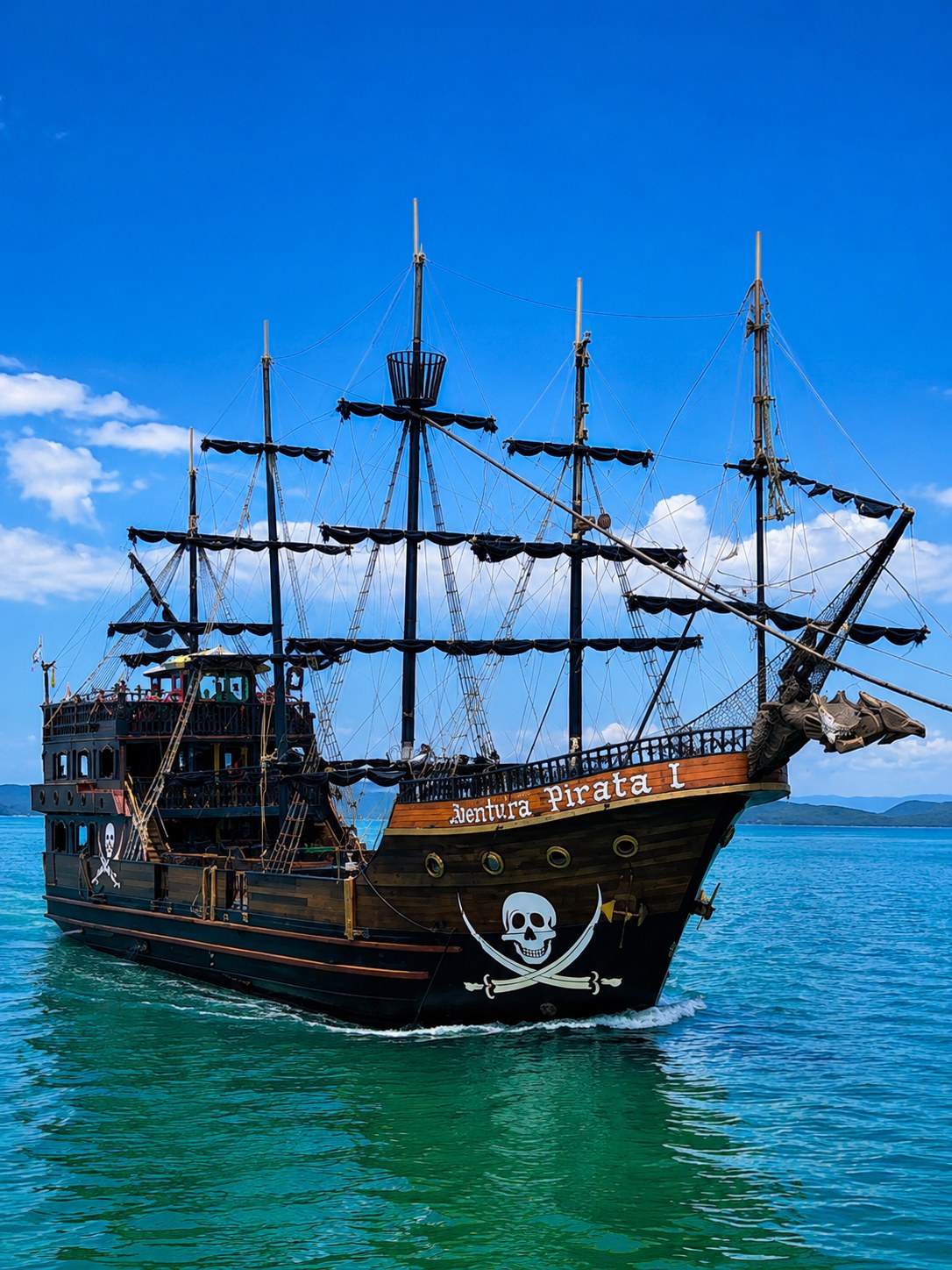 Barco pirata navegando próximo à orla com edifícios ao fundo